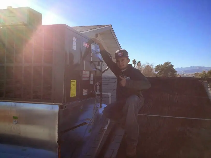 HVAC technician performing Heat Pump Repair on a rooftop unit in Dallas